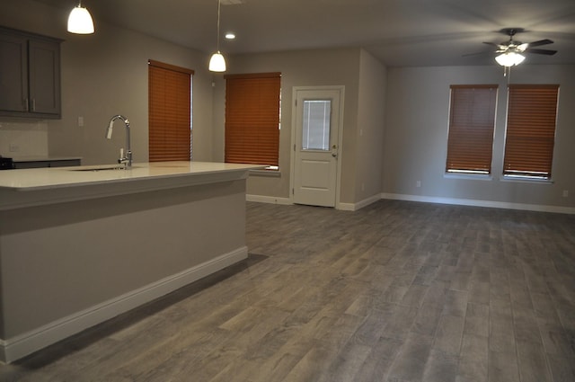 kitchen with hanging light fixtures, ceiling fan, sink, and dark hardwood / wood-style floors