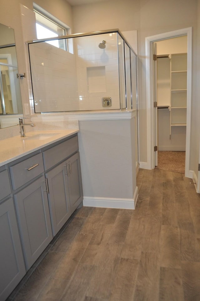 bathroom with wood-type flooring, vanity, and walk in shower