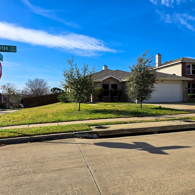 view of front of house featuring concrete driveway, an attached garage, and a front lawn