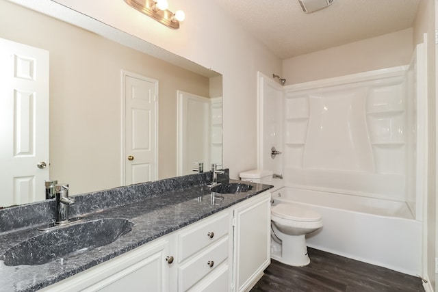 full bathroom featuring toilet, a textured ceiling, vanity, shower / bath combination, and hardwood / wood-style floors