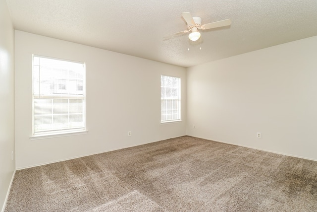 spare room with carpet, a textured ceiling, and ceiling fan