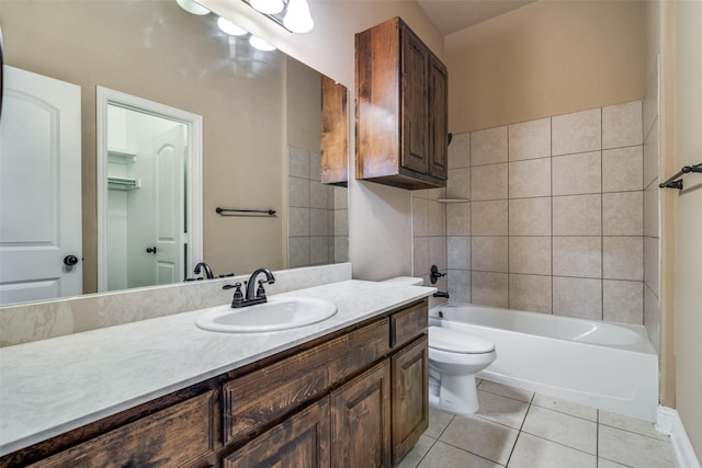 full bathroom with tile patterned flooring, vanity, tiled shower / bath, and toilet