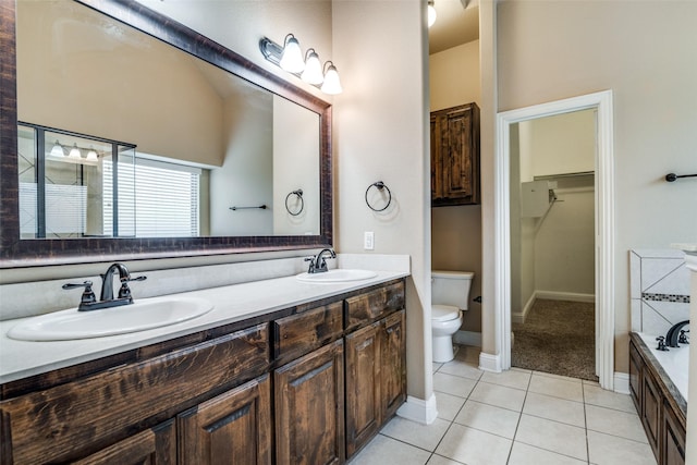 bathroom featuring vanity, a bathtub, tile patterned floors, and toilet