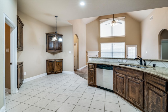 kitchen featuring pendant lighting, dishwasher, sink, dark brown cabinetry, and light stone countertops