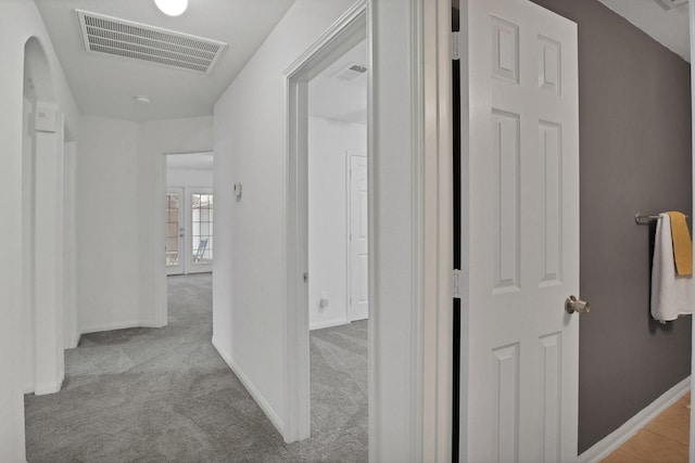 hallway featuring light colored carpet