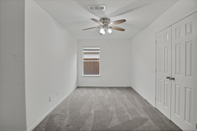 carpeted spare room featuring ceiling fan