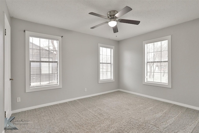 carpeted spare room featuring ceiling fan and a textured ceiling