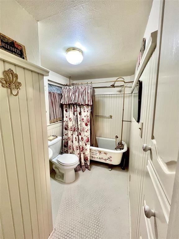 bathroom featuring tile patterned flooring, toilet, and a textured ceiling