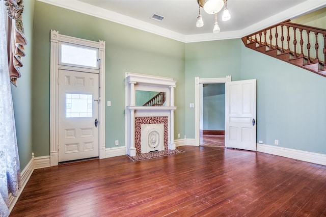 entryway with ornamental molding and hardwood / wood-style floors