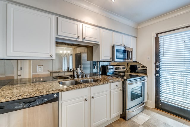 kitchen with light stone counters, stainless steel appliances, sink, and white cabinets