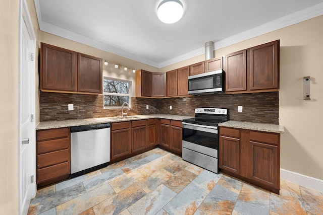 kitchen featuring light stone countertops, stone tile floors, decorative backsplash, appliances with stainless steel finishes, and a sink