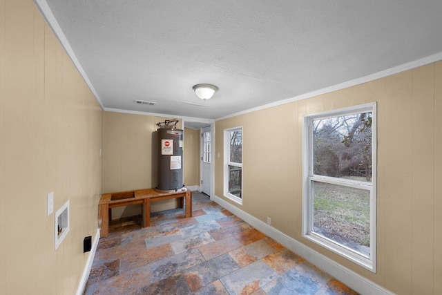 315 Park St, Commerce, TX 75428 - unfurnished room featuring electric water heater, crown molding, baseboards, stone finish flooring, and a textured ceiling