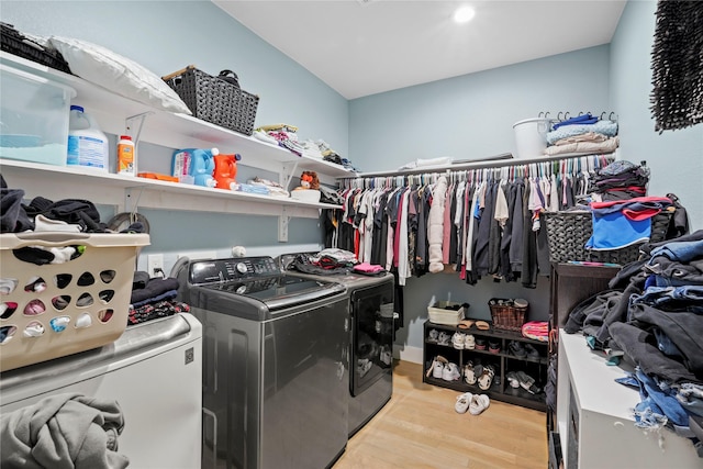 laundry area with washer and clothes dryer and light wood-type flooring