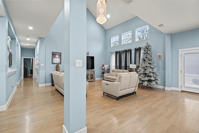 living room featuring a high ceiling and light hardwood / wood-style flooring