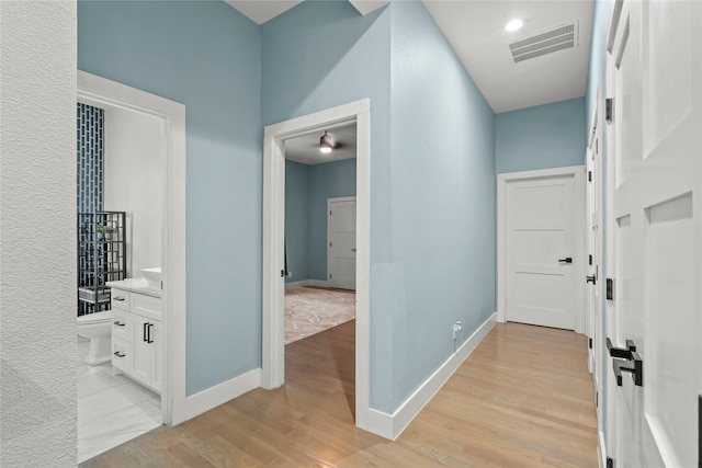 hallway with light hardwood / wood-style floors