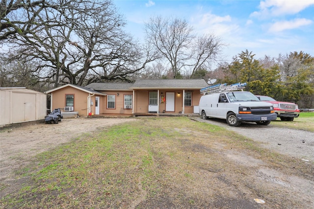 view of front of house with a storage unit and a front yard