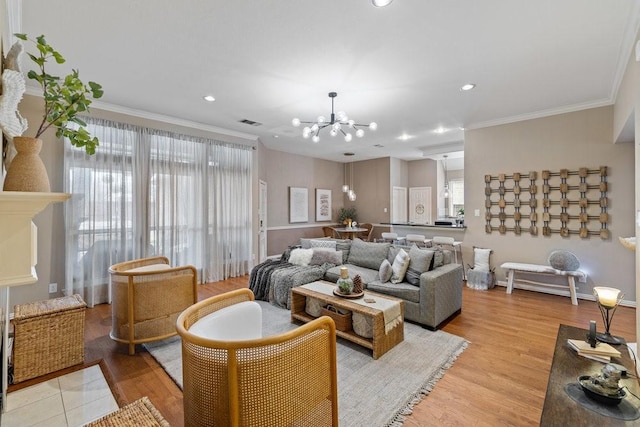 living room with a notable chandelier, light hardwood / wood-style flooring, and ornamental molding