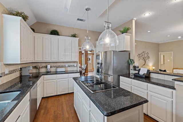 kitchen featuring pendant lighting, white cabinetry, stainless steel appliances, a kitchen island, and decorative backsplash