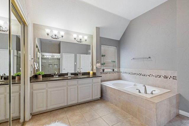 bathroom with shower with separate bathtub, lofted ceiling, tile patterned flooring, vanity, and a notable chandelier