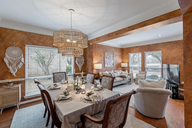 dining space with an inviting chandelier, hardwood / wood-style floors, and crown molding