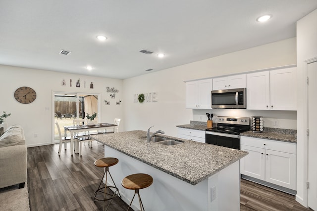 kitchen with stainless steel appliances, a kitchen island with sink, sink, and white cabinets