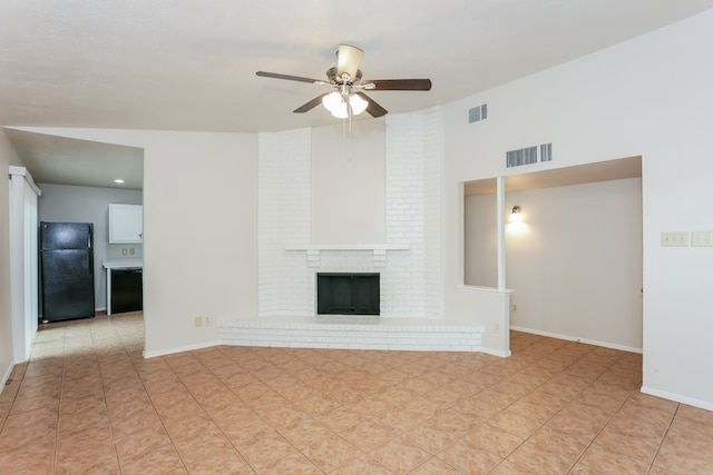 unfurnished living room with a brick fireplace, light tile patterned floors, and ceiling fan