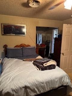 bedroom with ceiling fan and a textured ceiling