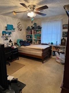 carpeted bedroom with ceiling fan and a textured ceiling