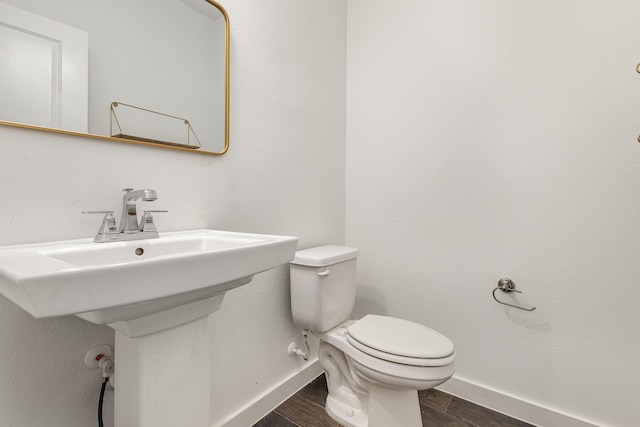 bathroom with wood-type flooring, toilet, and sink