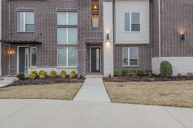 entrance to property featuring a lawn