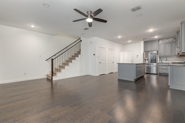 unfurnished living room with dark hardwood / wood-style floors and ceiling fan