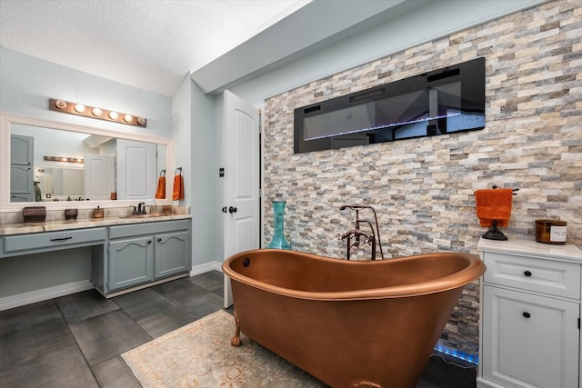 bathroom featuring vanity, a bathing tub, and a textured ceiling