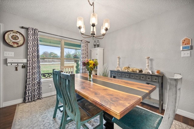 dining space with dark hardwood / wood-style flooring, a notable chandelier, and a textured ceiling