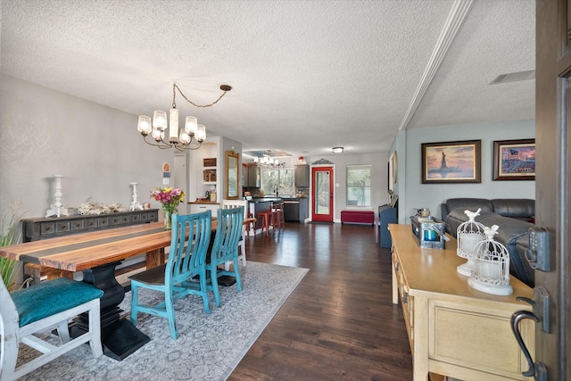 dining space with dark hardwood / wood-style flooring, a textured ceiling, and a chandelier