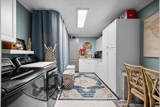 laundry area featuring light hardwood / wood-style flooring, independent washer and dryer, and a textured ceiling