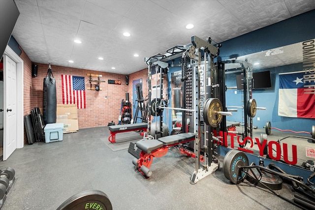 workout area featuring brick wall