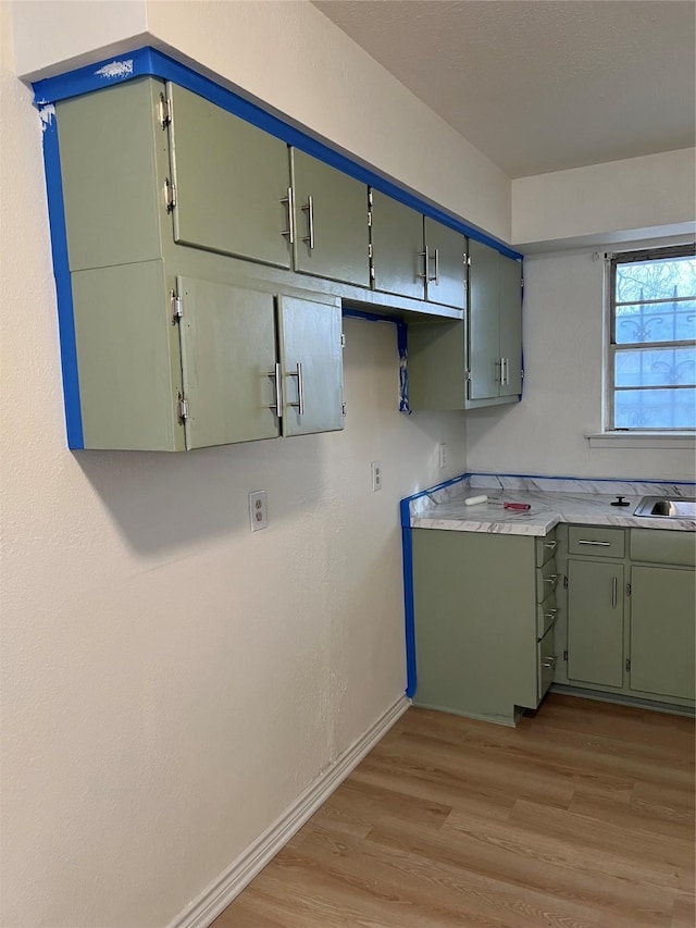 kitchen with light hardwood / wood-style floors and green cabinetry