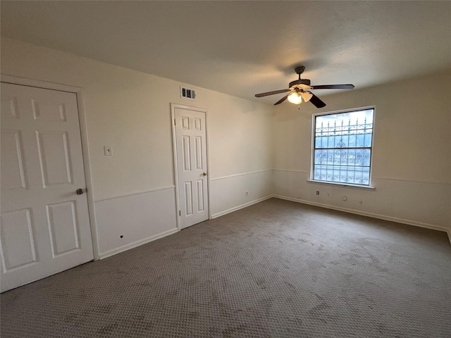 carpeted spare room featuring ceiling fan