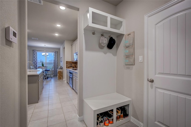 mudroom featuring light tile patterned flooring, a chandelier, and sink