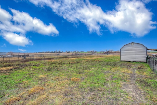 view of yard with a shed and a rural view