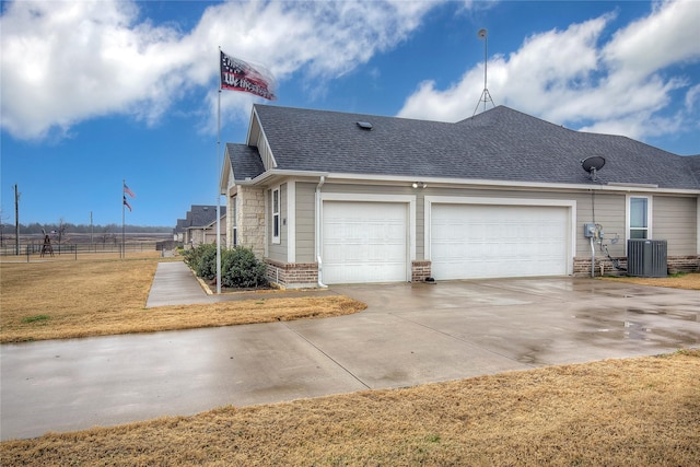 view of side of property with a garage and central AC