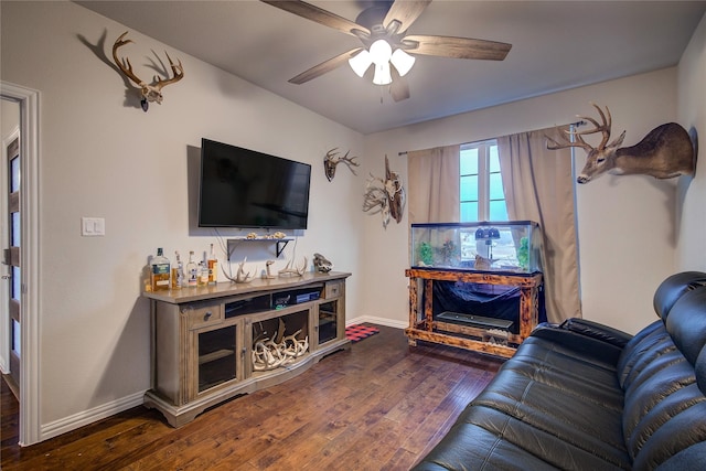 living room featuring ceiling fan and dark hardwood / wood-style floors