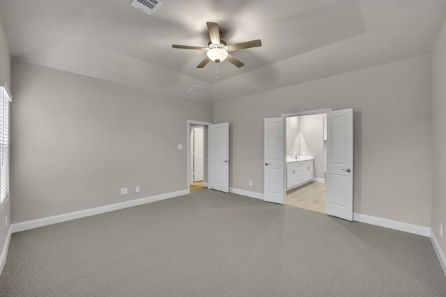 unfurnished bedroom with ceiling fan, lofted ceiling, connected bathroom, and light carpet