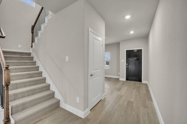 stairs featuring recessed lighting, wood finished floors, and baseboards