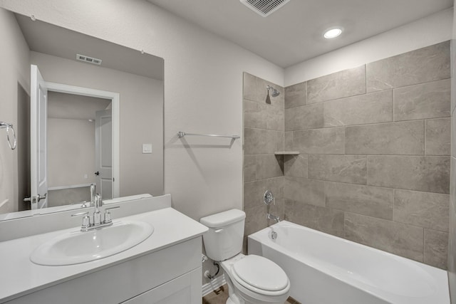 full bathroom featuring tiled shower / bath, vanity, and toilet