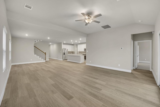 unfurnished living room featuring lofted ceiling, light hardwood / wood-style floors, and ceiling fan