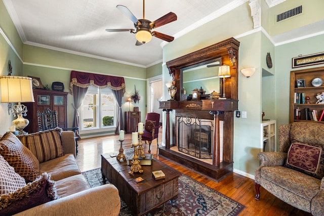 living room with crown molding, ceiling fan, and wood-type flooring