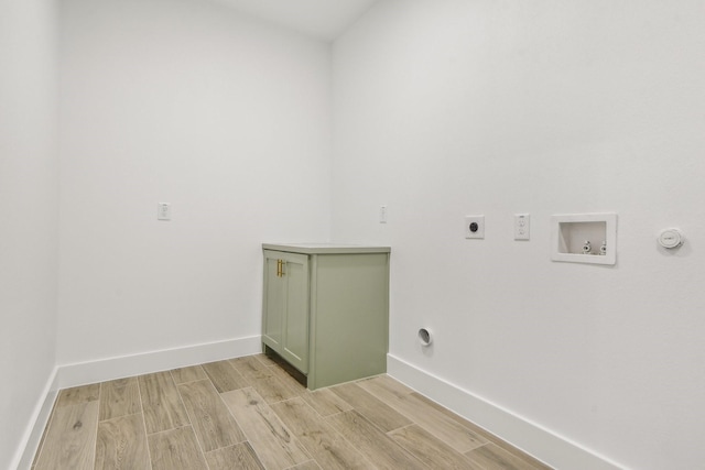 clothes washing area featuring cabinets, hookup for a gas dryer, washer hookup, hookup for an electric dryer, and light wood-type flooring