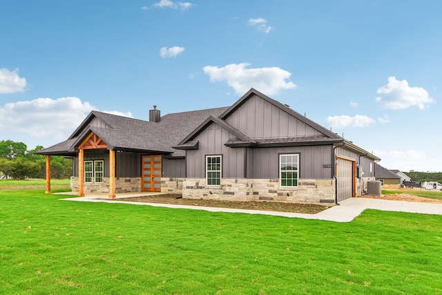 back of property with cooling unit, a yard, and a garage