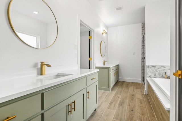 bathroom with independent shower and bath, wood-type flooring, and vanity